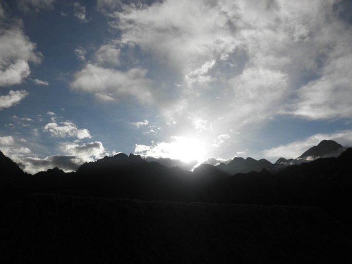 The sun peeking out over the mountain. 